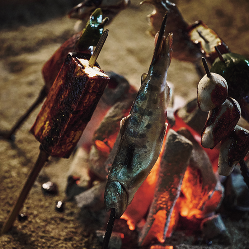 在圍爐裏的炭火旁取暖的同時