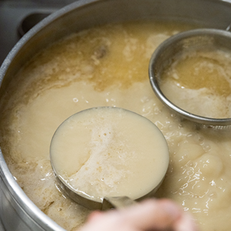 豚の頭の骨を巨大な釜で炊きあげるスープ
