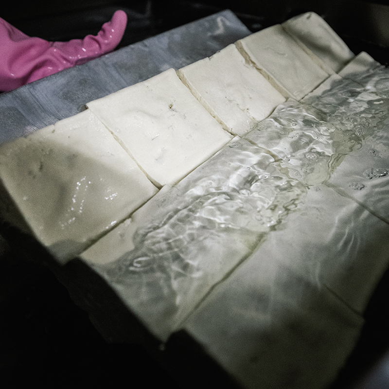 即使在炎熱的製作場裡，依然耐心地仔細油炸。